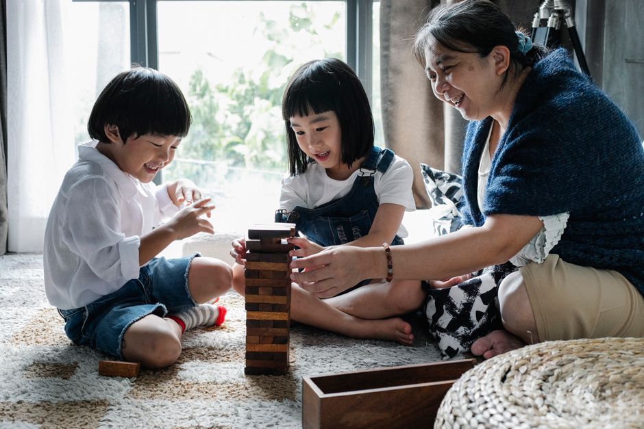 アジアの子供たちと遊ぶ年配の女性